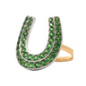 A horseshoe-shaped ring featuring rows of round green gemstones set in silver-toned metal, with a yellow gold band visible on the right side, isolated on a white background.