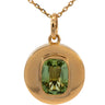 A gold pendant necklace featuring a round bezel-set green gemstone on a delicate gold chain, shown against a plain white background.
