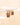 A pair of gold-toned beaded hoop earrings hanging from a clear display bar against a warm cream background with soft light flares.